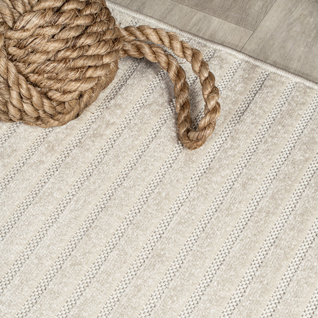 Ivory and cream rug corner with braided border detail and thin horizontal stripes