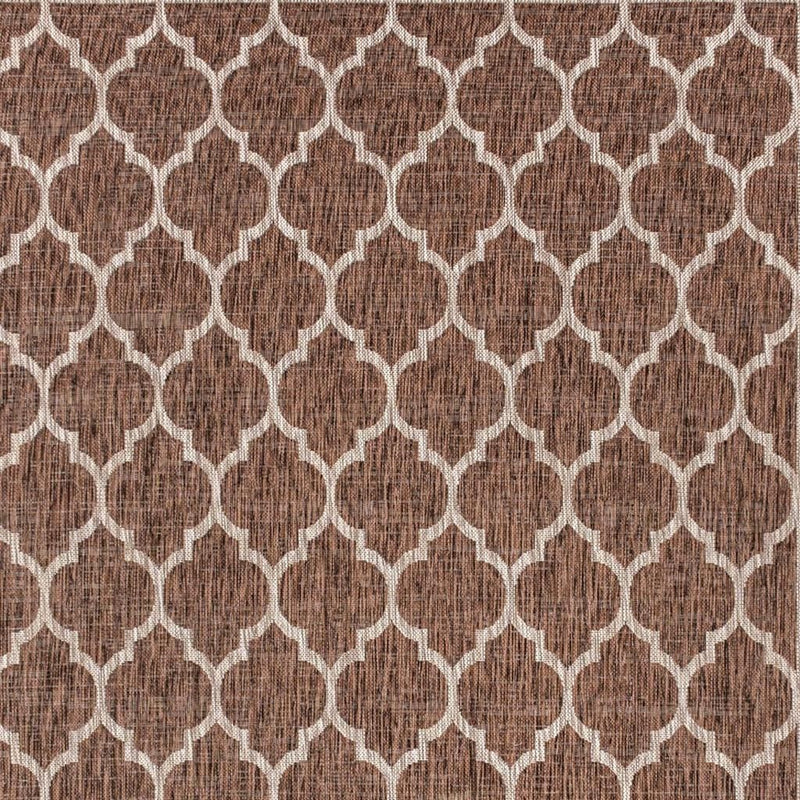 Close-up geometric indoor outdoor rug in espresso brown with taupe linked shapes
