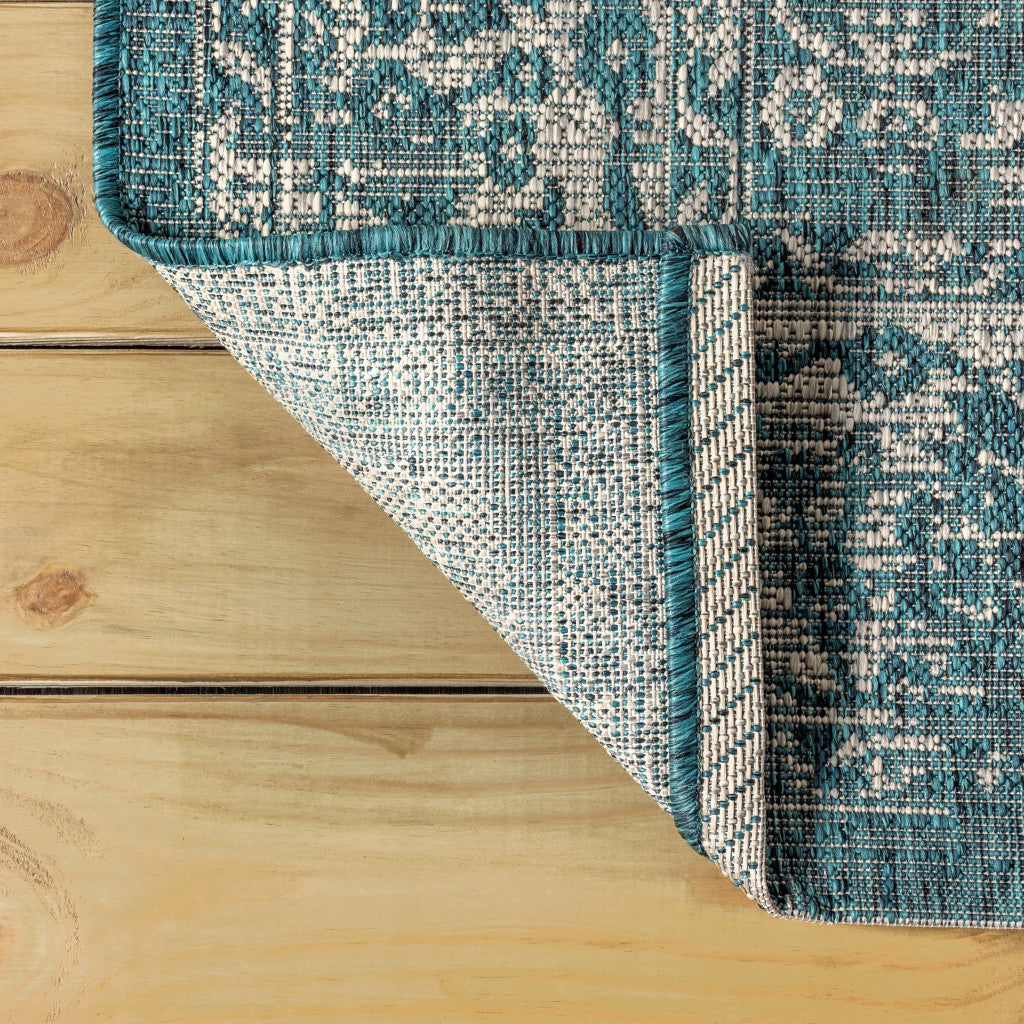 Teal and gray area rug corner with medallion pattern and border