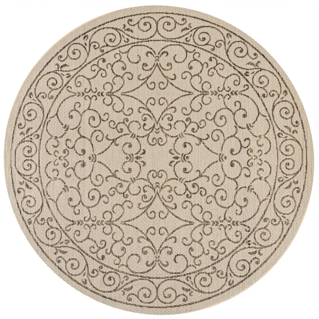 Round beige indoor/outdoor rug with brown scrolling floral medallion border pattern