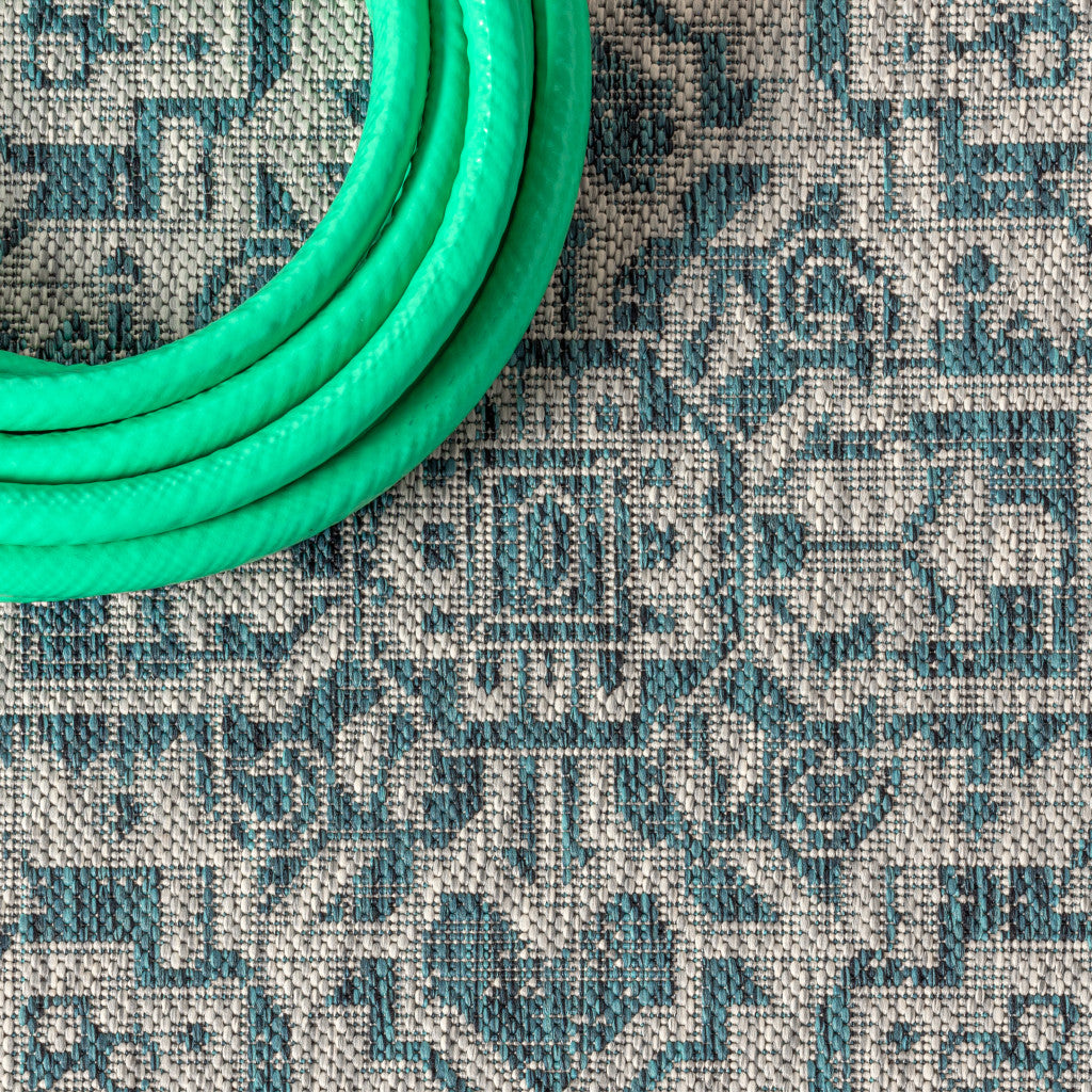 Close-up of round rug surface with teal blue and gray geometric medallion pattern