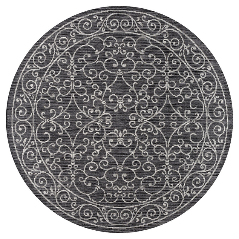 Round black and gray rug featuring a white scrollwork medallion and decorative border