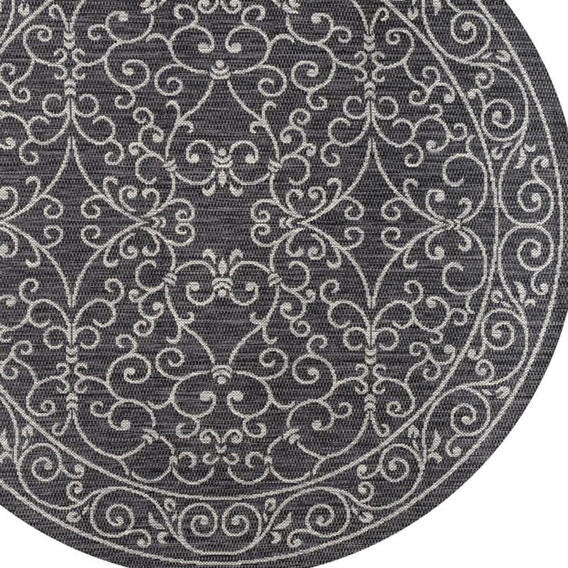 Close-up of round rug medallion pattern in dark gray with light gray scroll details