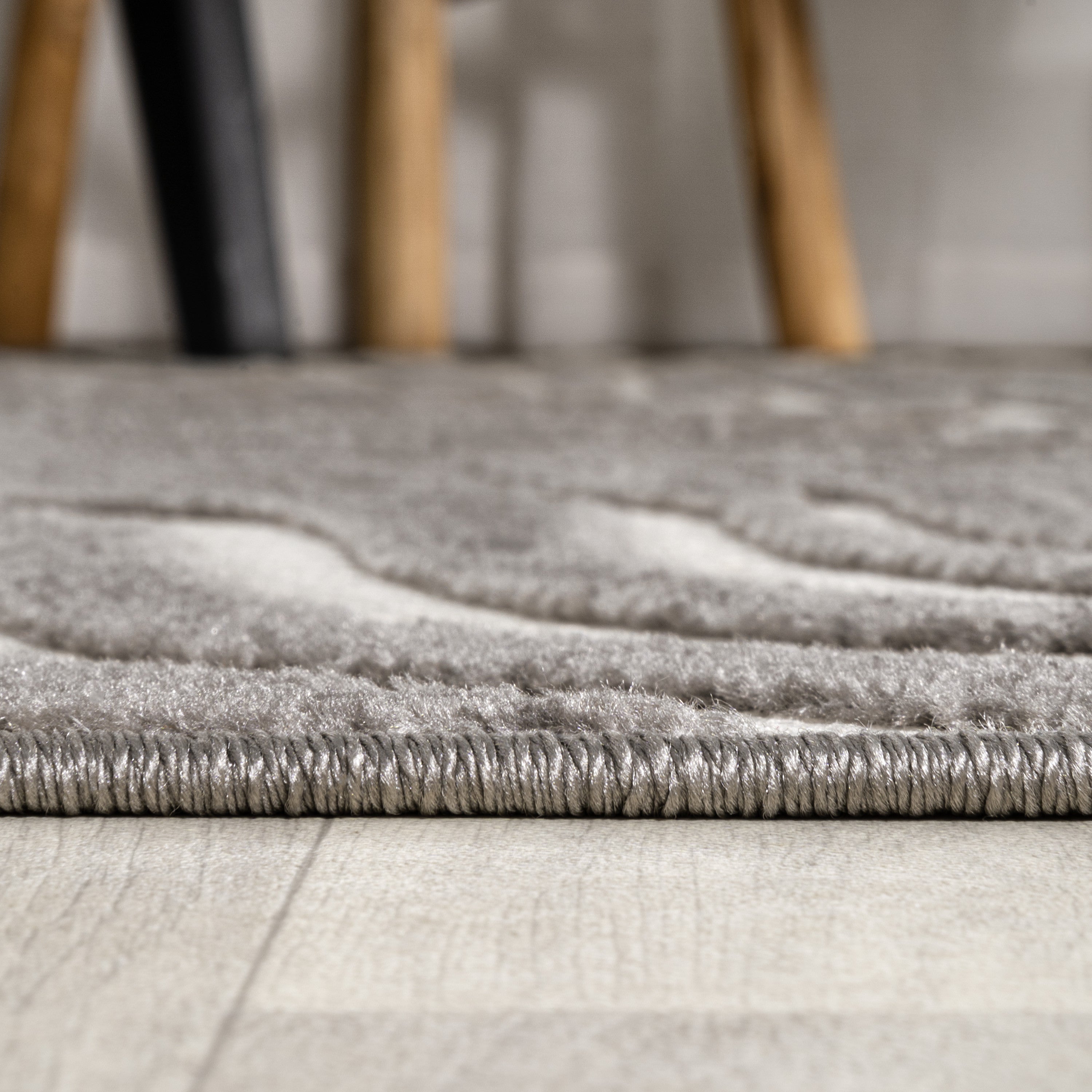 Gray and ivory rug texture with low pile and stitched edge border