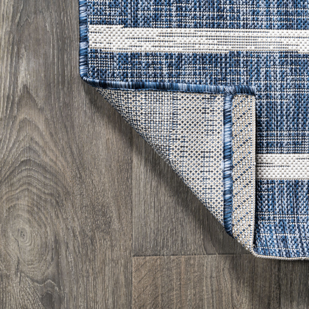 Corner view of blue and ivory striped area rug with dark stitched border