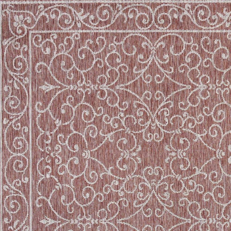 Indoor/outdoor area rug with rose-brown floral scroll medallion pattern on beige background
