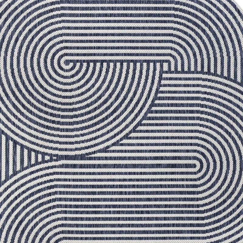 Cream and navy abstract area rug with curving striped swirls, angled close-up.