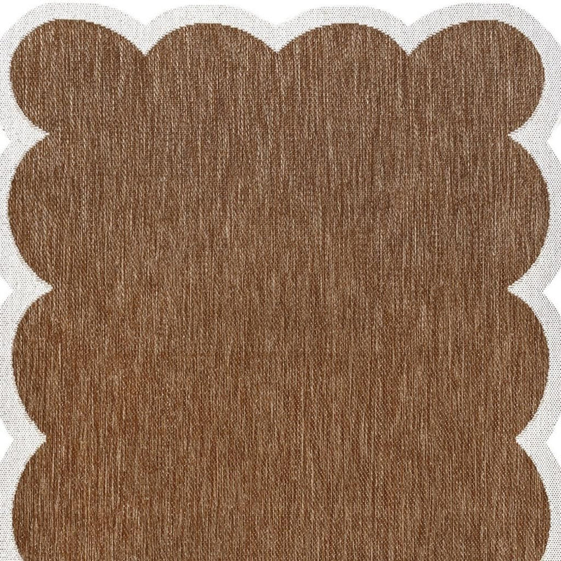 Brown textured area rug with scalloped cream edge