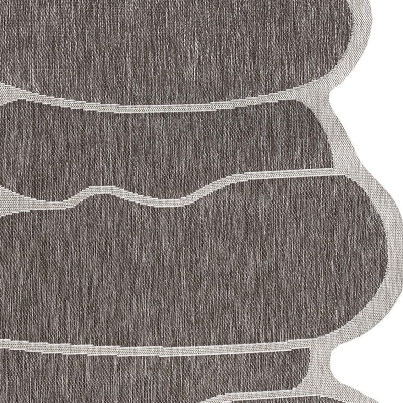 Indoor/outdoor area rug close-up showing dark gray texture and light beige wave lines