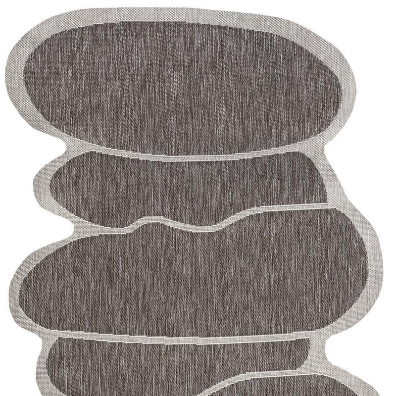 Indoor/outdoor area rug abstract medallion with stacked dark gray shapes and light edging