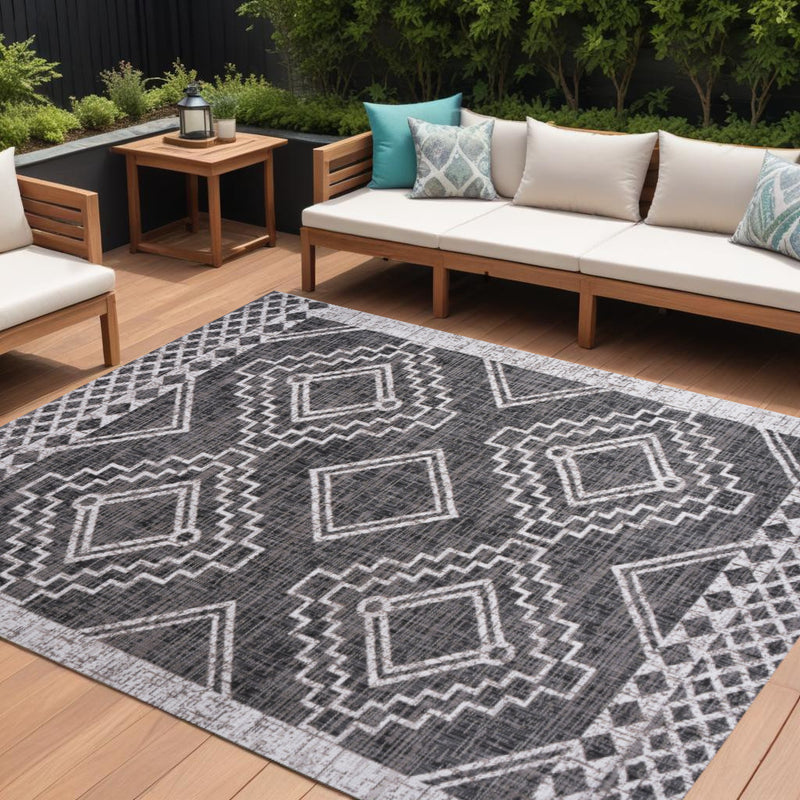 Moroccan geometric area rug in black and ivory with large diamond motifs and zigzag trim.