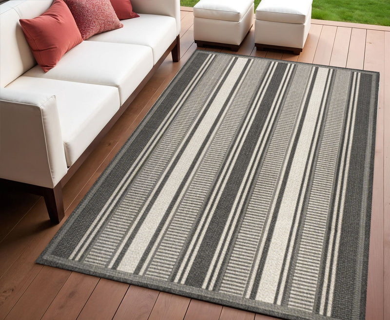 Indoor/outdoor striped area rug in black and cream on hardwood floor
