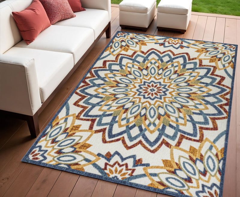 Indoor/outdoor area rug with multicolor medallion floral pattern, blue red yellow on floor