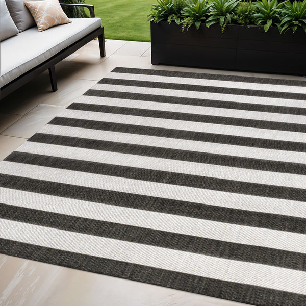 Indoor/outdoor area rug with black and cream horizontal stripes, flat woven design
