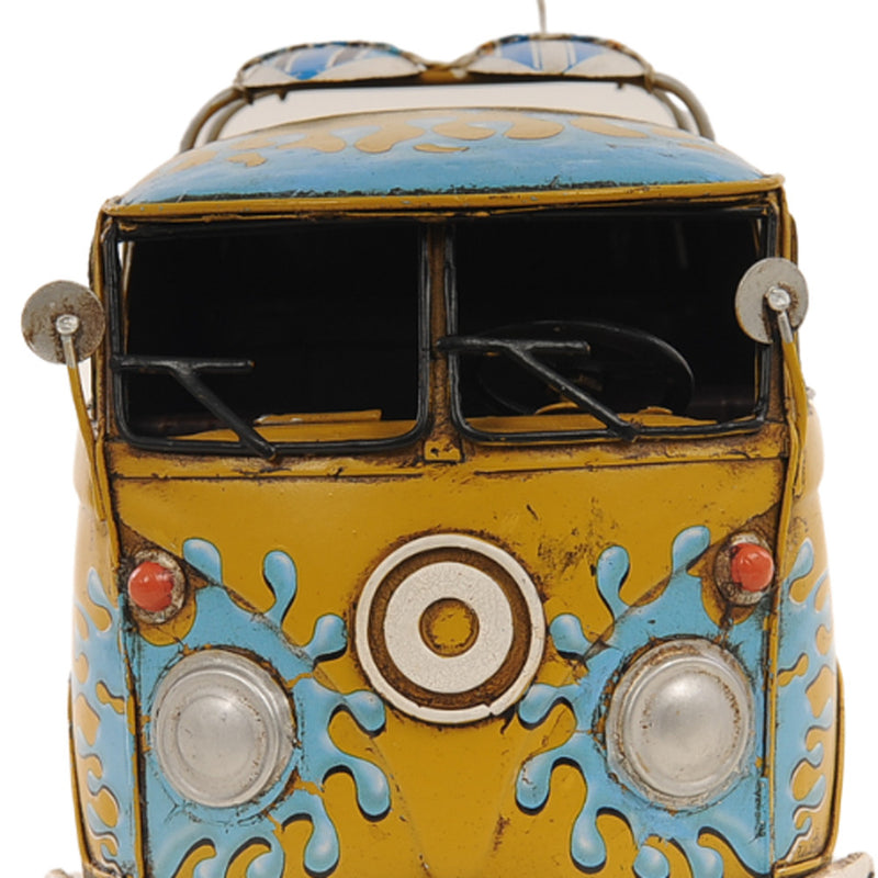 Yellow metal model van front view with blue paint splashes and round emblem at grille.