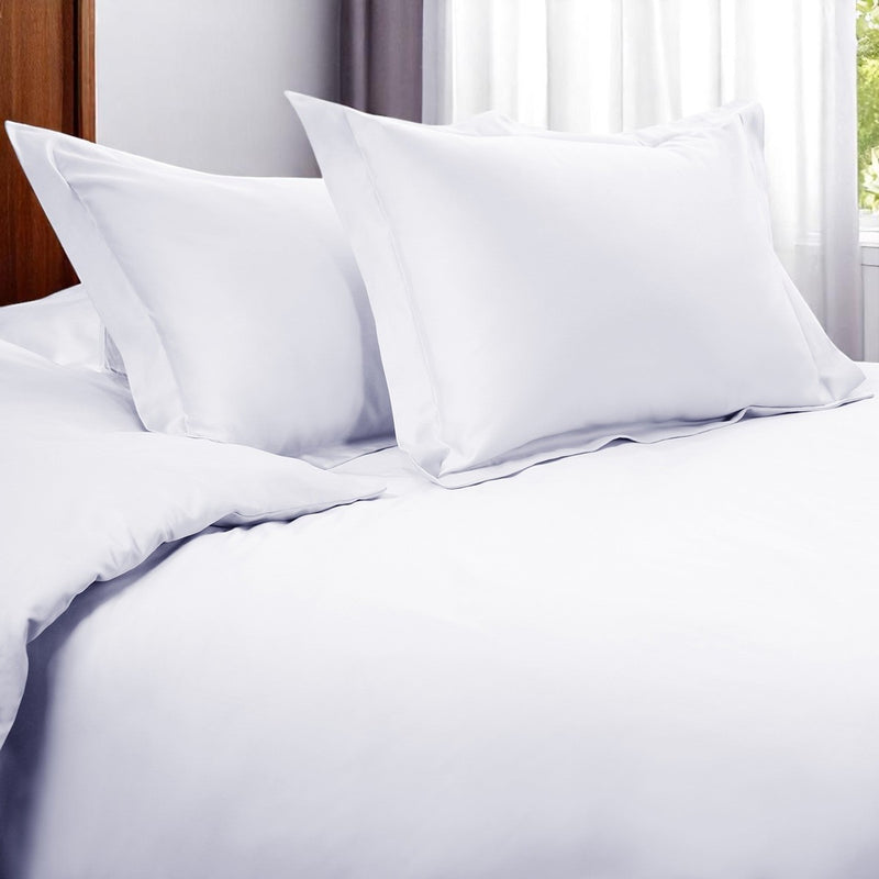 White duvet cover set with two shams and duvet comforter cover on a bed
