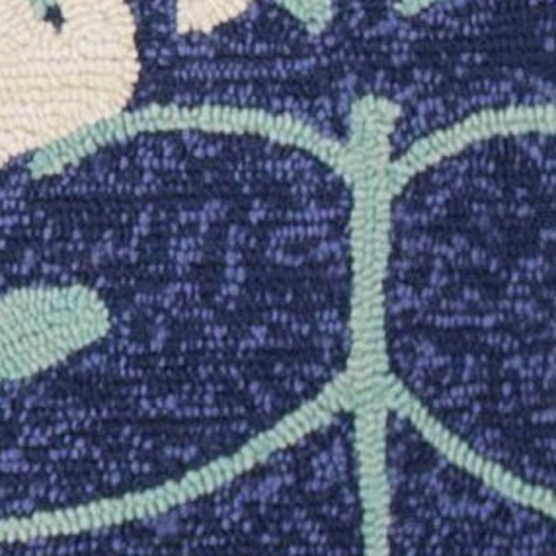 Detail of dark navy circular leaf motif with turquoise outline on area rug