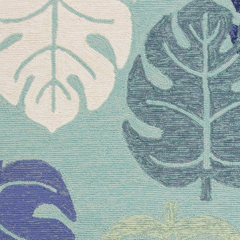 Turquoise leaf-pattern area rug with navy and cream floral motifs