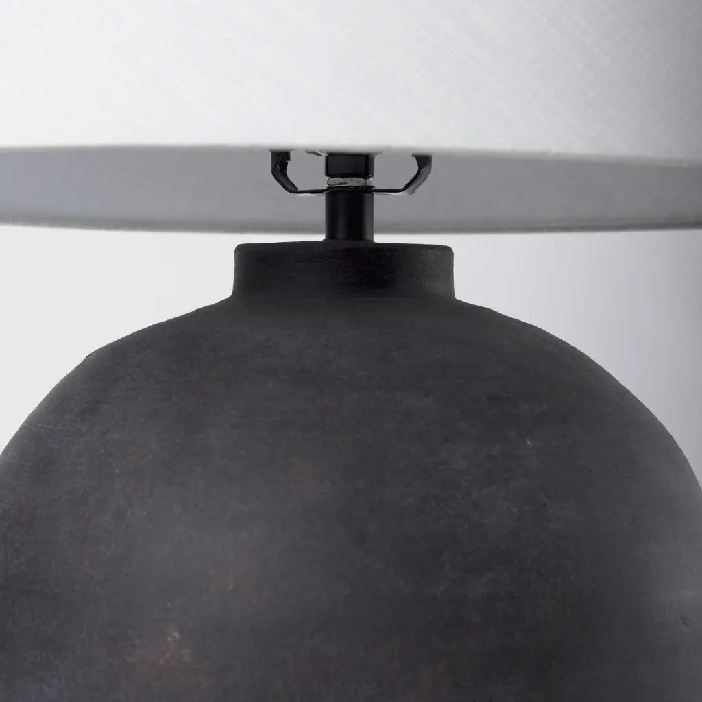 Modern black ceramic table lamp with a white fabric shade and a sleek, minimalist design.