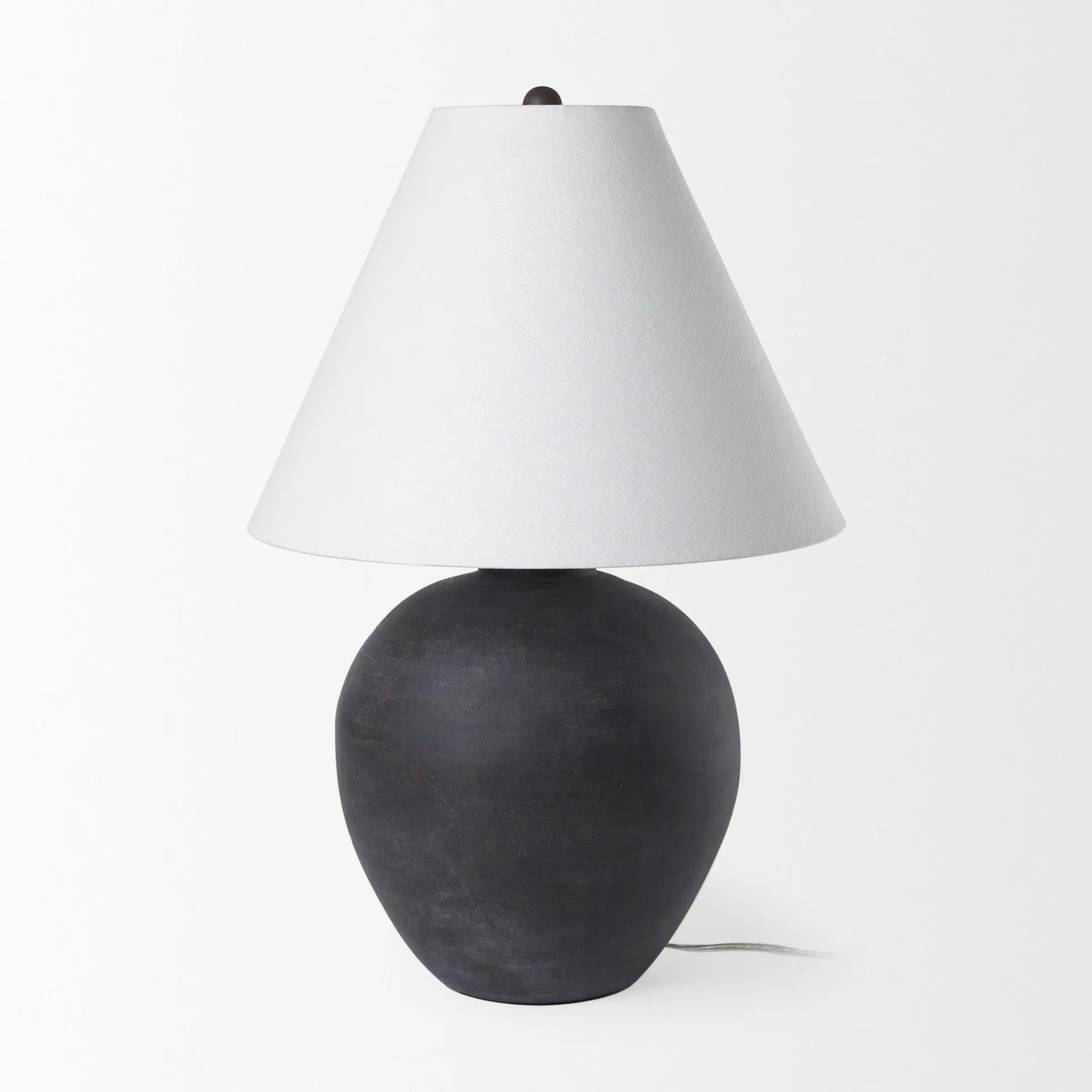 Black ceramic table lamp with a white fabric shade, featuring a modern, minimalist design.