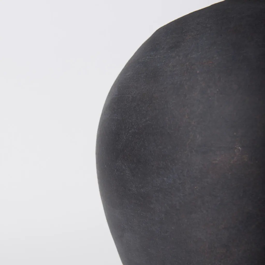 Handcrafted black ceramic vase with a matte finish, featuring organic curves for a modern decor touch.