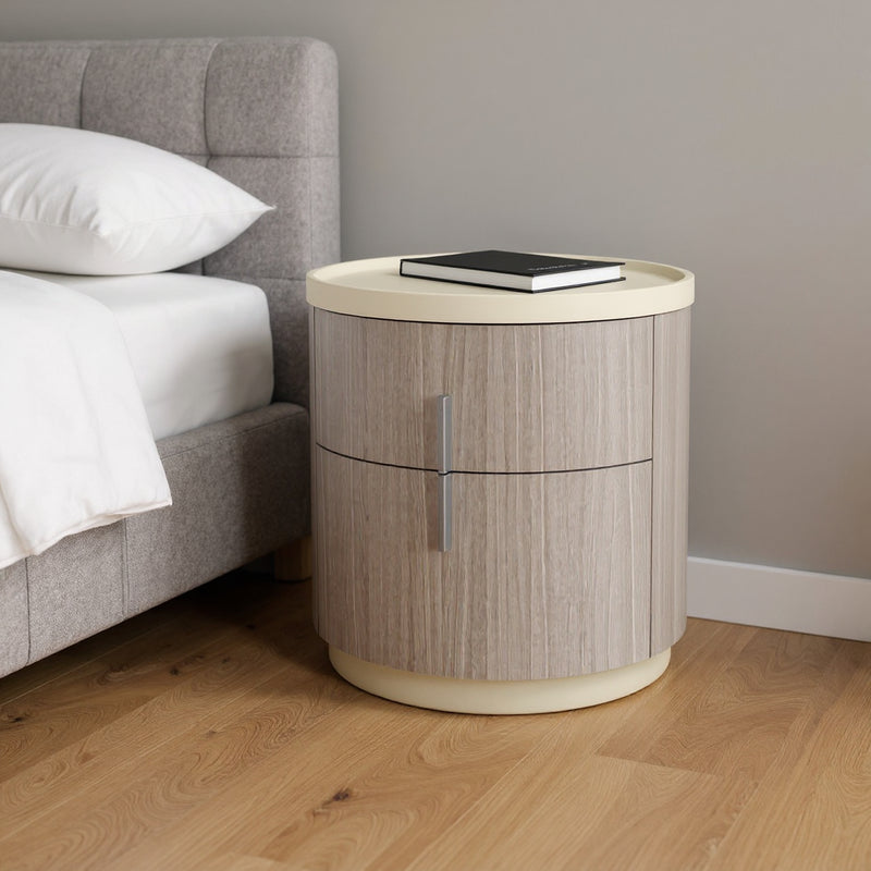 Round two-drawer nightstand with beige top and oak wood finish, vertical drawer pull