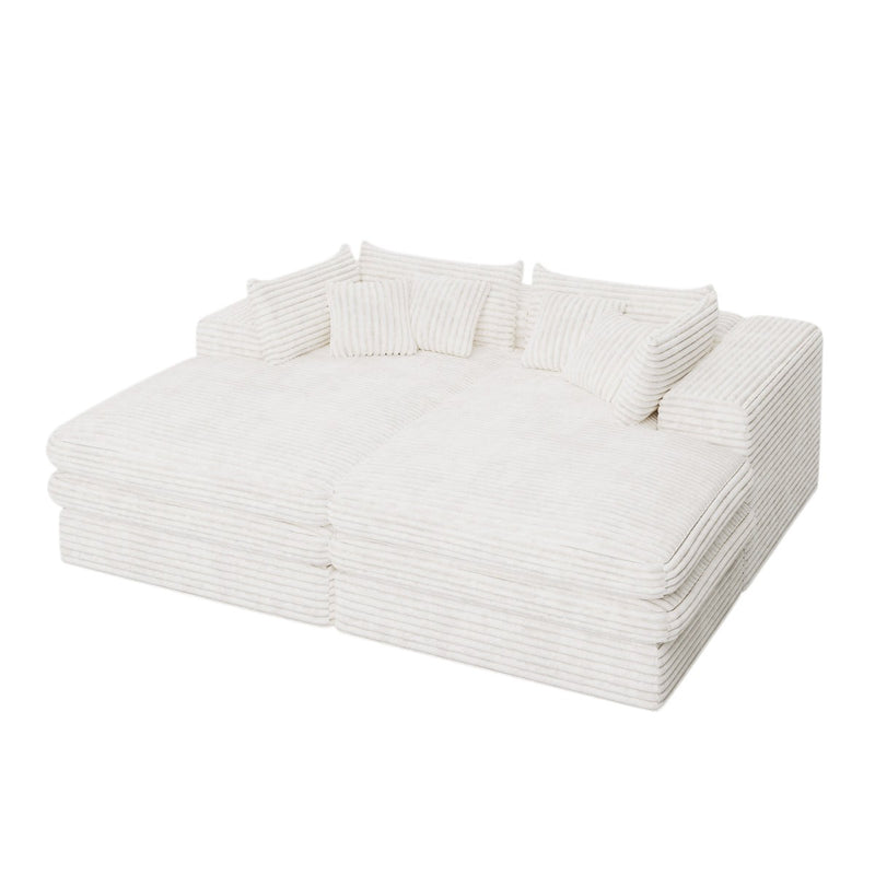 White corduroy chaise lounge with multiple toss pillows, angled view