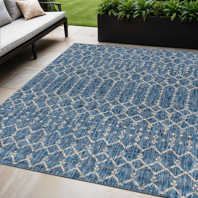 Indoor/outdoor rug with navy and light gray diamond trellis pattern, angled view