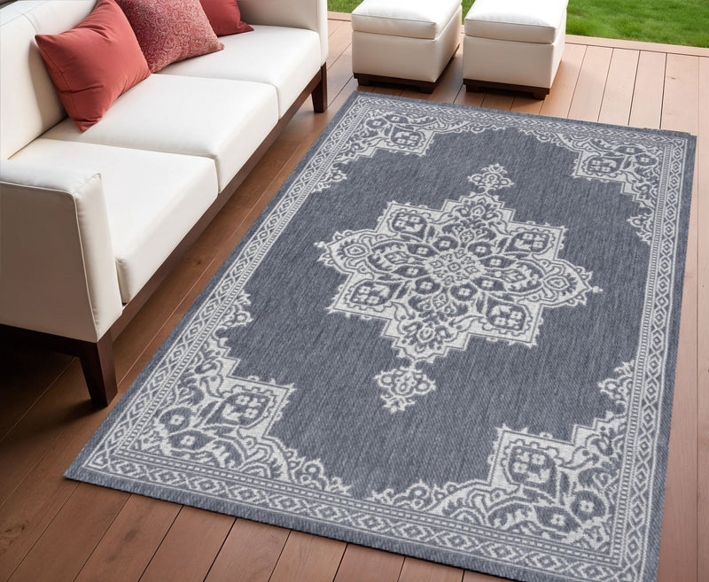 Blue and cream medallion area rug with patterned border, on hardwood floor