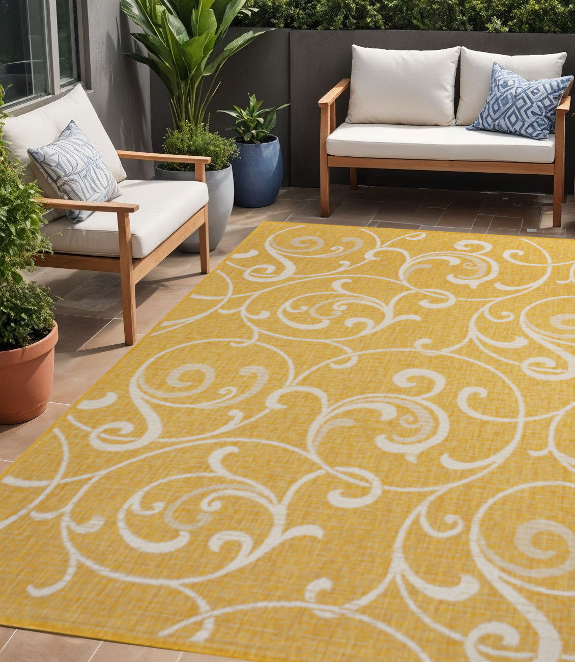 Yellow outdoor area rug with cream floral swirls laid on patio floor