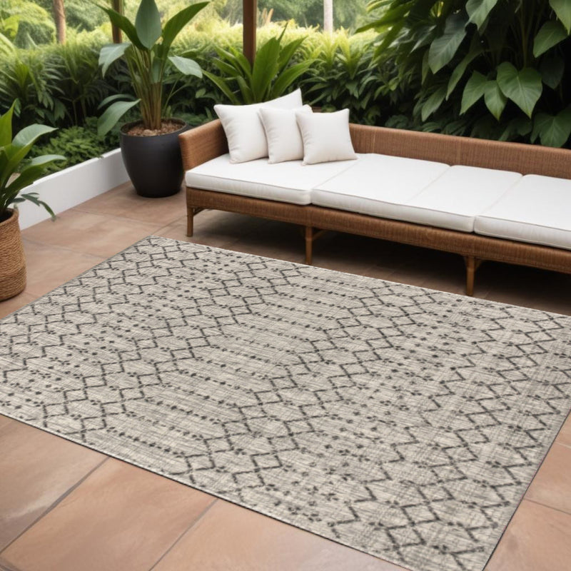 Light gray outdoor area rug with black trellis pattern, laid flat