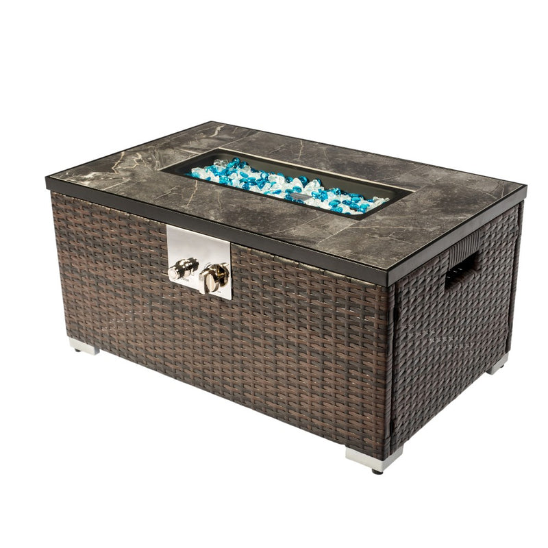 Rectangular propane fire pit table with brown rattan sides, stone top, and blue glass
