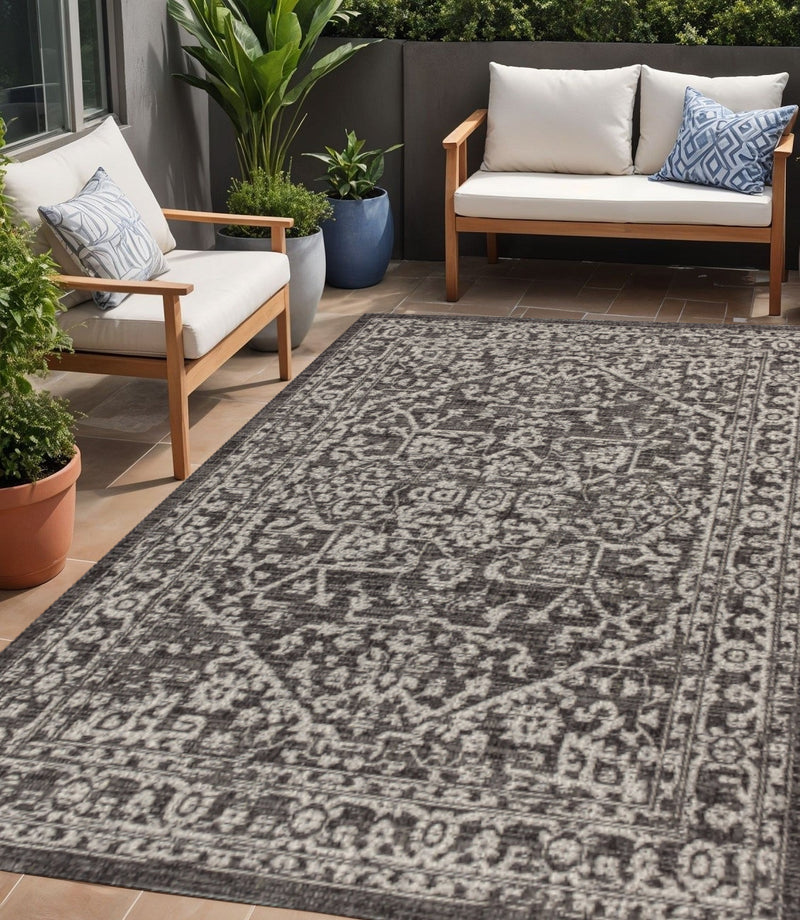 Black and gray medallion area rug with ornate border pattern