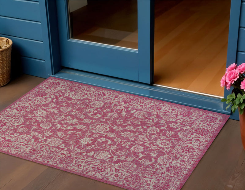 Rectangular fuchsia and light gray medallion area rug on hardwood floor