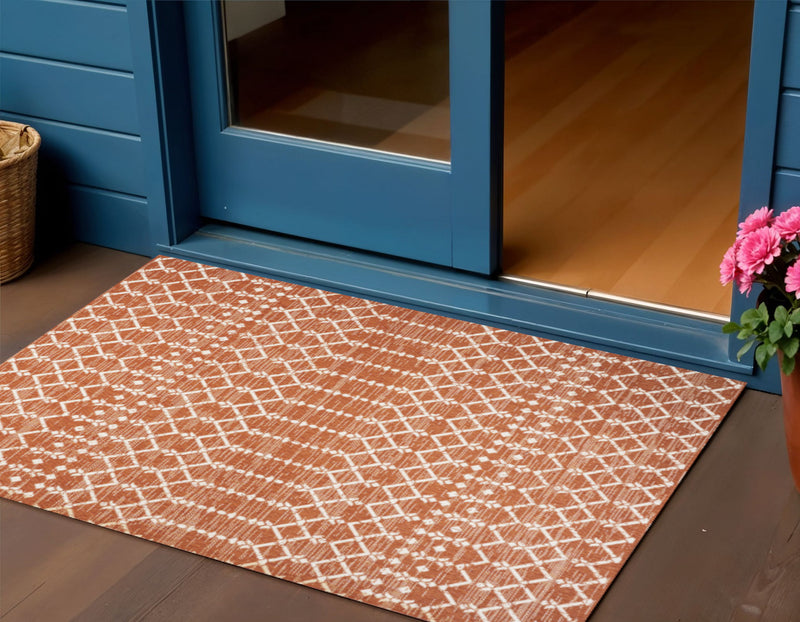 Orange and cream trellis area rug with diamond lattice design laid in an entryway