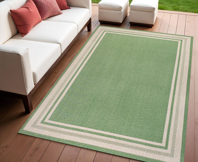 Green and cream indoor outdoor area rug with square frame pattern