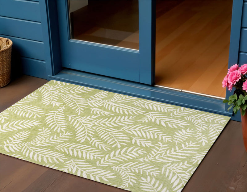 Green and cream leaf-pattern area rug laid on floor, indoor/outdoor style