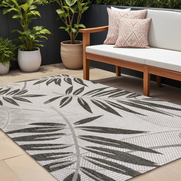Gray and black leaf floral area rug with geometric border for indoor or outdoor spaces