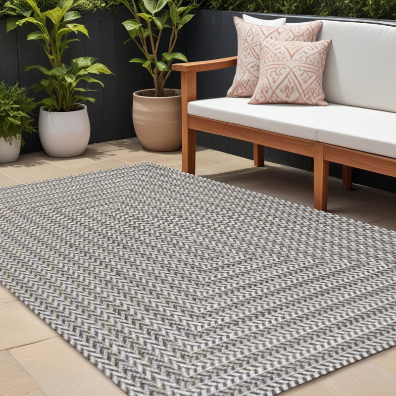 Indoor outdoor area rug with dark and light gray zigzag stripe pattern, flat weave