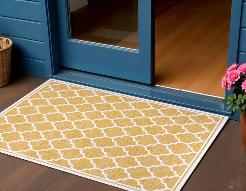 Yellow and cream geometric indoor/outdoor area rug with white border