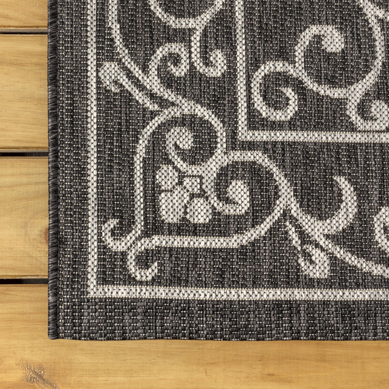 Black and gray medallion runner rug close-up with scrolling filigree pattern
