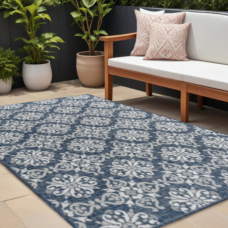 Navy blue area rug with cream ornamental floral medallions, rectangular layout.