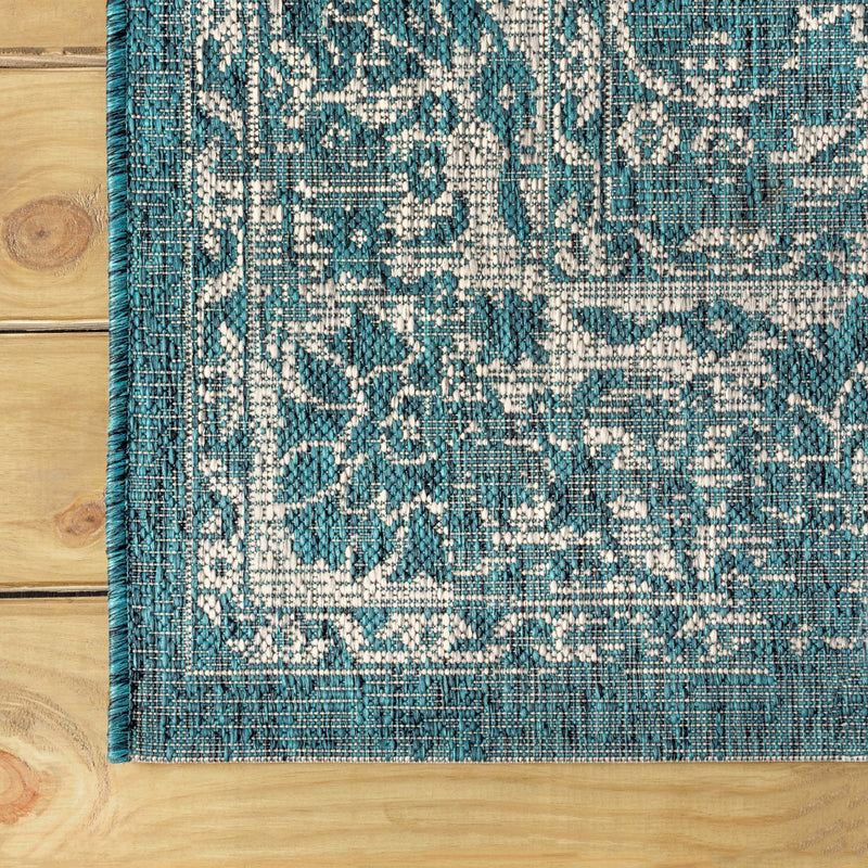 Teal and gray medallion area rug edge with detailed pattern