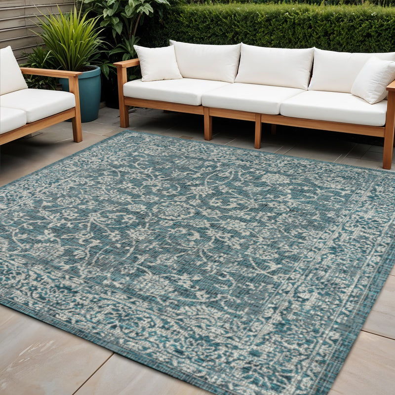 Teal and gray square medallion indoor/outdoor area rug on patio