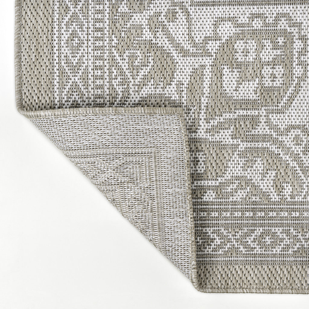 Beige and cream patterned area rug showing woven texture and stitched edge