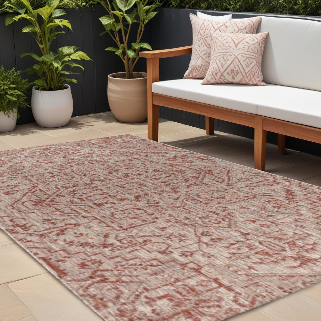 Indoor outdoor area rug with red-and-taupe medallion pattern, distressed motif