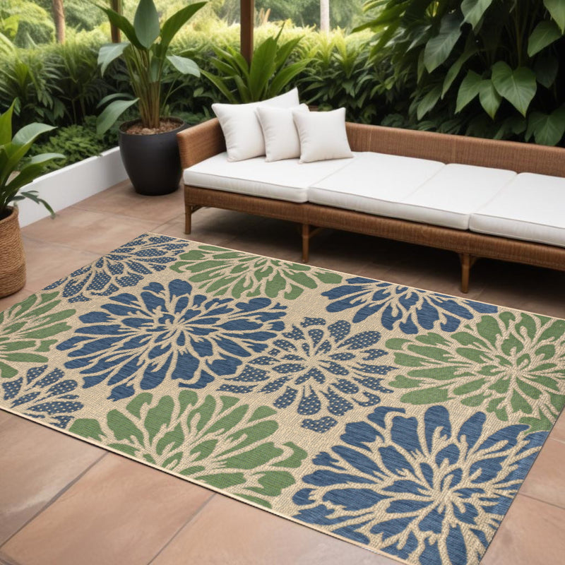 Indoor/outdoor floral area rug with navy and green medallion design on light base
