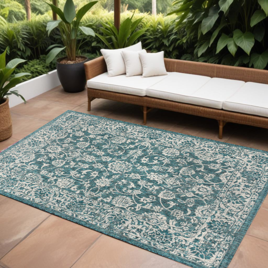 Teal blue area rug with ornate medallion pattern, 10x14 ft, border edge