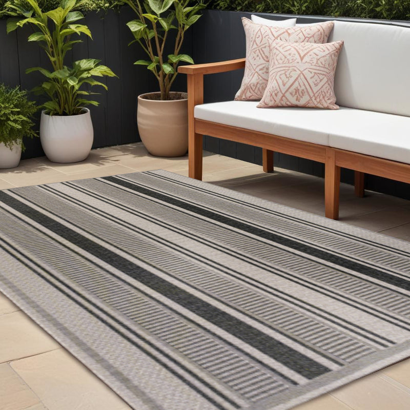Rectangular striped area rug with dark and beige vertical lines on outdoor patio