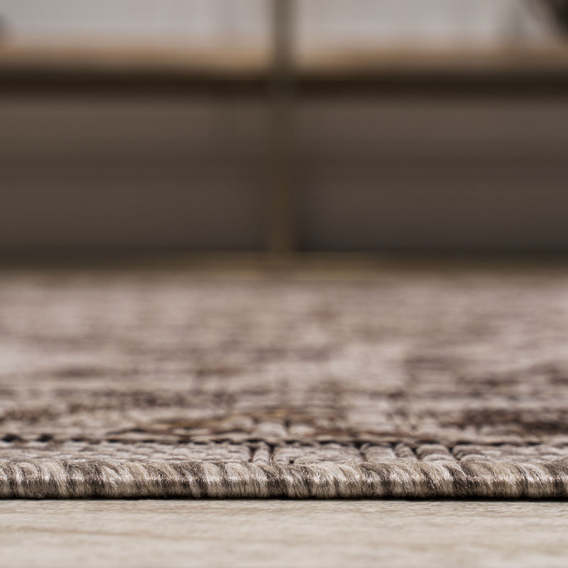 Runner rug corner showing low pile texture on a light floor surface.
